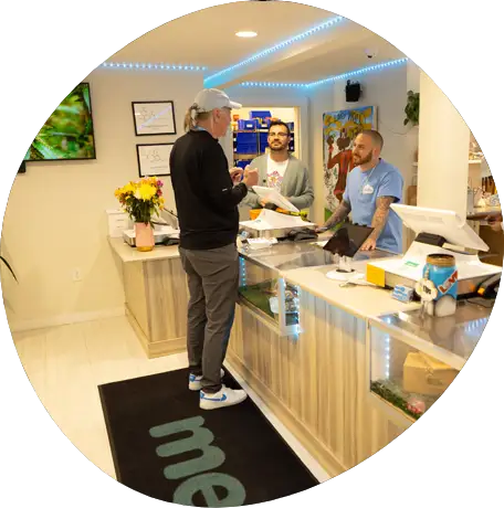 Inside Mello Cannabis dispensary showing a customer interacting with friendly staff at the front counter.